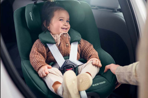 Wygodny fotelik Maxi-Cosi i-Size, uśmiechnięte dziecko z pasami