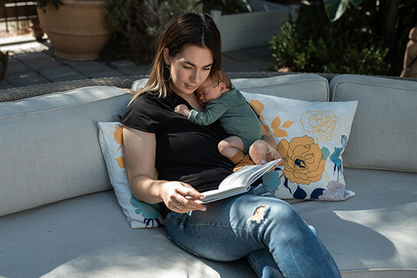 Mama odpoczywająca z niemowlęciem na rękach, wyciszenie i bliskość podczas skoków rozwojowych