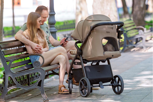 Wózek spacerowy Carrello Bravo SL z wentylacją w budce, śpiące dziecko podczas spaceru w parku.