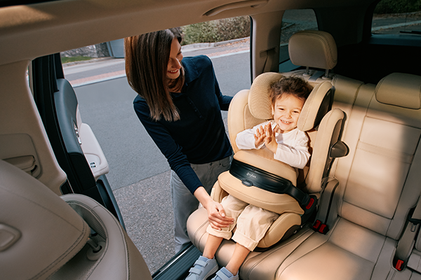 Mama zapinająca dziecko w foteliku Cybex Pallas G3 w samochodzie